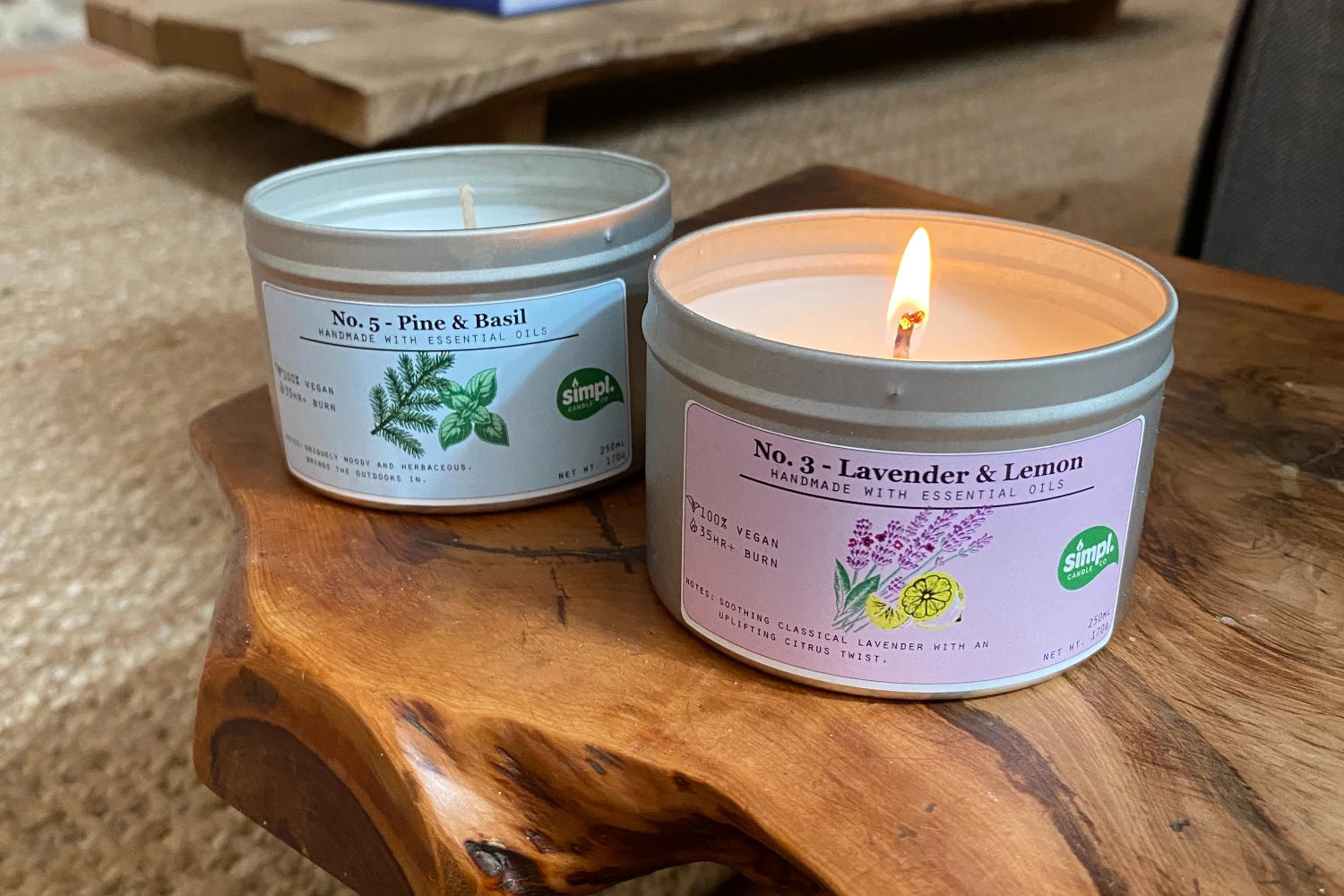 Two candles with labels on a wooden surface