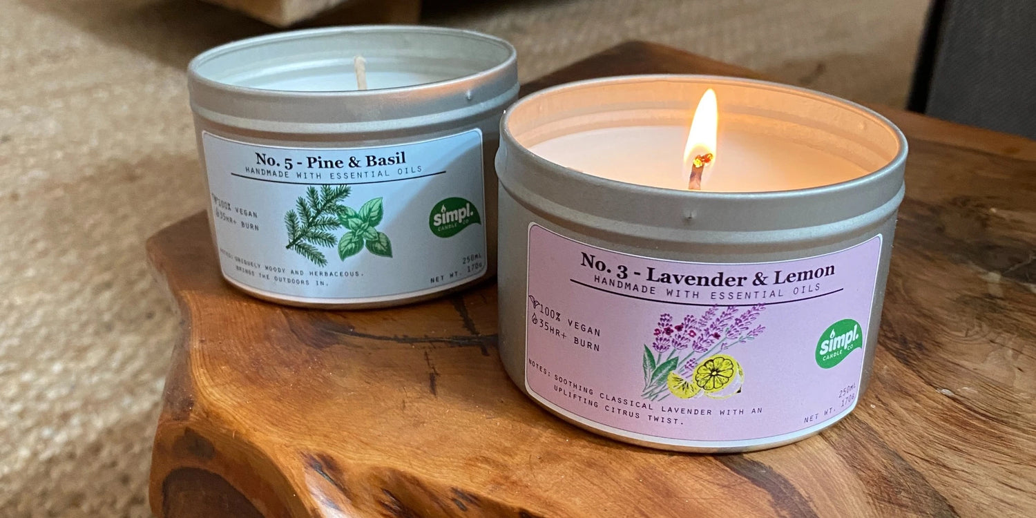 Two candles with labels on a wooden surface