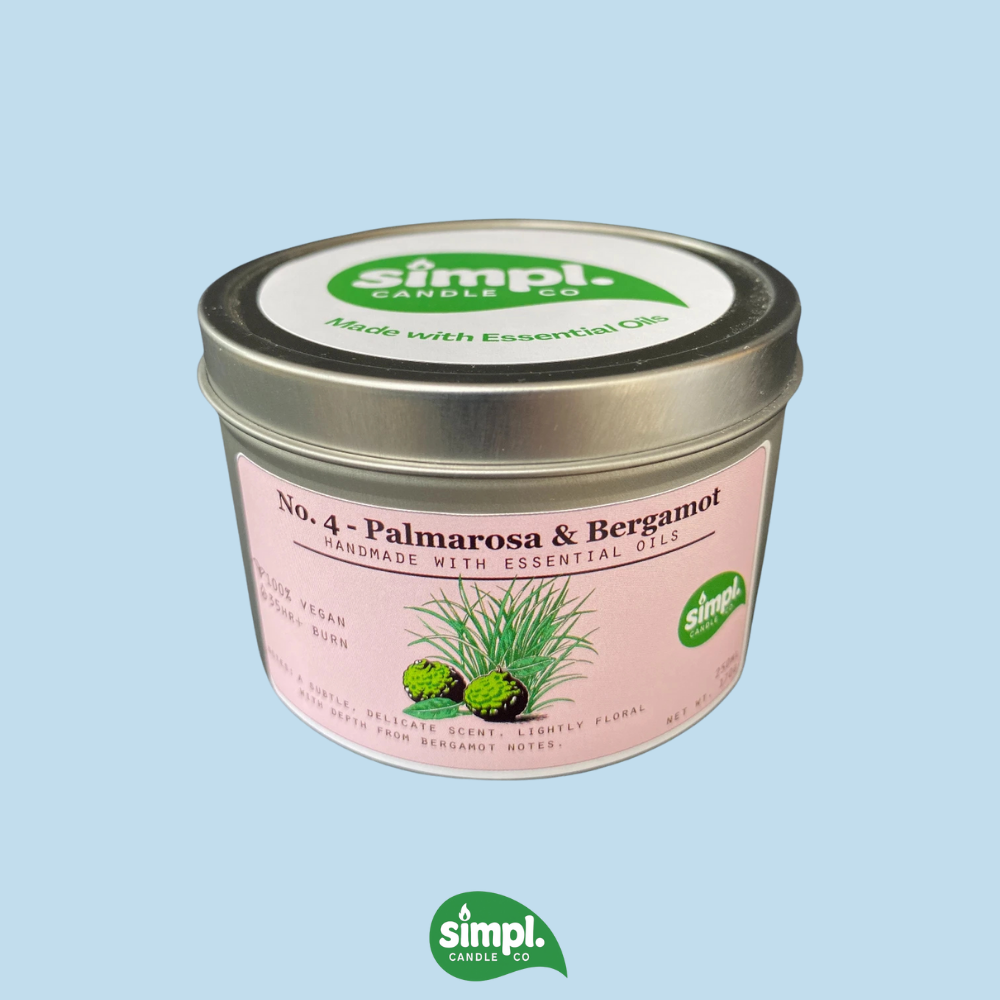 Simpl Candle tin with pink label on a light blue background