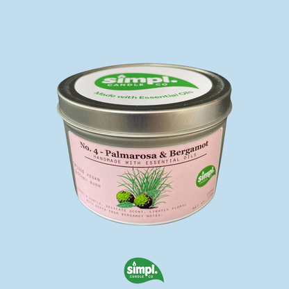 Simpl Candle tin with pink label on a light blue background
